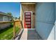 Modern home entrance with a vibrant red door, wooden accents, and a secure, gated entry, enhancing curb appeal at 1026 St Peter St, Indianapolis, IN 46203