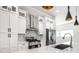 Modern kitchen with white cabinets, stainless steel appliances, an island with seating, and stylish pendant lighting at 1026 St Peter St, Indianapolis, IN 46203