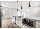 Open concept kitchen featuring white cabinets, stainless appliances, granite countertops and modern pendant lighting at 1026 St Peter St, Indianapolis, IN 46203