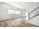 Sunlit living room with wood-look floors, sleek railing, and large windows, offering a bright and airy open space at 1026 St Peter St, Indianapolis, IN 46203