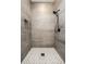 Modern walk-in shower with gray tiles, a mosaic floor, and a sleek showerhead at 1026 St Peter St, Indianapolis, IN 46203