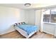 Simple bedroom featuring a full-sized bed with blue covers, a large window, and hardwood floors at 10321 Starview Dr, Indianapolis, IN 46229