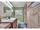 Bathroom features stone accents, tiled shower, and vanity with storage and decor at 10407 Stillwell Ct, Avon, IN 46123