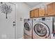 Convenient laundry room equipped with a modern washer and dryer set and overhead cabinets at 10407 Stillwell Ct, Avon, IN 46123