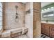 Custom tiled shower with bench and showerhead along with niche in remodeled bathroom at 10407 Stillwell Ct, Avon, IN 46123