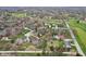 Expansive aerial view of a neighborhood featuring mature trees, lush greenery, and a nearby golf course with scenic ponds at 108 Wesley Cir, Noblesville, IN 46062