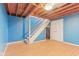 Unfinished basement with bright blue walls, stairs, and door ready for customization at 108 Wesley Cir, Noblesville, IN 46062