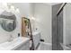 A modern bathroom features dual vanities, stylish light fixtures, and a glass-door shower with tile surround at 108 Wesley Cir, Noblesville, IN 46062