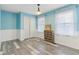 Bright bedroom with pale blue walls, white trim, a large closet, and wood-look floors with a lovely accent piece at 108 Wesley Cir, Noblesville, IN 46062