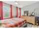 A cozy bedroom with a plaid comforter, dresser, and bright red curtains offering natural light at 108 Wesley Cir, Noblesville, IN 46062