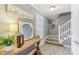 Welcoming foyer with a decorated console table, mirror, and staircase leading to the upper level at 108 Wesley Cir, Noblesville, IN 46062