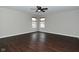 Light-filled bedroom with ceiling fan, dark wood floors, and two windows offering natural light at 11188 Giddings Pl, Noblesville, IN 46060