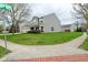 View of the gray two-story home on a corner lot, showing the green grass and landscaped yard at 11188 Giddings Pl, Noblesville, IN 46060