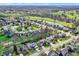 This aerial view shows a neighborhood situated by a river and a golf course, with tree-lined streets at 11247 Reflection Point Dr, Fishers, IN 46037