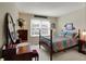 Bedroom featuring a bed with floral print, a window, a wooden vanity with mirror and neutral carpet at 11247 Reflection Point Dr, Fishers, IN 46037