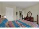 Bedroom featuring a wooden vanity with mirror, a bed with floral print and neutral carpet at 11247 Reflection Point Dr, Fishers, IN 46037