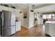 Kitchen with stainless steel refrigerator, wood floors, and access to multiple rooms at 11247 Reflection Point Dr, Fishers, IN 46037