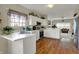 Traditional kitchen features white cabinetry, wood floors, and an open layout to the living room at 11247 Reflection Point Dr, Fishers, IN 46037
