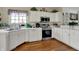 Bright kitchen with white cabinets, stainless steel appliances, and wood flooring at 11247 Reflection Point Dr, Fishers, IN 46037