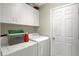 Bright laundry room with white cabinets, a modern washer and dryer set, and a white door at 11247 Reflection Point Dr, Fishers, IN 46037
