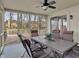 Relaxing sunroom with screened windows, ceiling fan, outdoor views, and a dining table set at 11247 Reflection Point Dr, Fishers, IN 46037