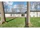 A grassy backyard features bare trees, the back of a home, and a paver patio and lawn at 11921 Westwood Dr, Carmel, IN 46033