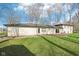 A grassy backyard features bare trees and the back of a brick and siding house at 11921 Westwood Dr, Carmel, IN 46033