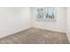 Bright bedroom features neutral carpet, white trim, and a window with backyard view at 11921 Westwood Dr, Carmel, IN 46033