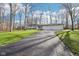 Long cracked driveway surrounded by trees and grass leads to a home at 11921 Westwood Dr, Carmel, IN 46033