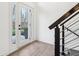 Modern entryway with a glass door, wood floors, and a metal railing at 11921 Westwood Dr, Carmel, IN 46033