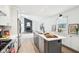 Modern kitchen with stainless steel appliances, a kitchen island, and an open view of a fireplace at 11921 Westwood Dr, Carmel, IN 46033