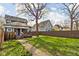 The backyard features a mature tree, a wood fence, and a concrete walkway at 1230 N Temple Ave, Indianapolis, IN 46201