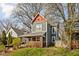 Well-maintained two-story home with colorful trim, mature trees, and a landscaped front yard at 1230 N Temple Ave, Indianapolis, IN 46201