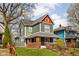 View of home with green and red trim, a brick foundation, and mature landscaping at 1230 N Temple Ave, Indianapolis, IN 46201