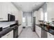 Contemporary kitchen with white cabinets, stainless steel appliances, and modern backsplash at 1230 N Temple Ave, Indianapolis, IN 46201