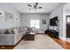 Comfortable living room with a large sectional, wood floors, and a ceiling fan at 1230 N Temple Ave, Indianapolis, IN 46201