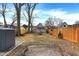 Large grassy backyard enclosed by a wooden fence and some mature trees at 1337 Linden St, Indianapolis, IN 46203