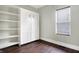 Bedroom featuring a built-in Murphy bed, shelving and a window with wood blinds, plus hardwood floors at 1337 Linden St, Indianapolis, IN 46203