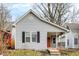 Charming single-story home featuring gray siding, black shutters, and an inviting front porch with an orange front door at 1337 Linden St, Indianapolis, IN 46203