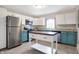Kitchen with stainless steel appliances, an island, white upper cabinets, and colored lower cabinets at 1337 Linden St, Indianapolis, IN 46203