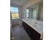 Well-lit bathroom featuring a double sink vanity with modern fixtures and a large window offering a neighborhood view at 13872 N Mardenis W Dr, Camby, IN 46113