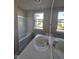 Well-lit bathroom featuring a double sink vanity with modern fixtures, large window and tub at 13872 N Mardenis W Dr, Camby, IN 46113