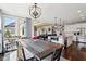 Open concept dining area with wood floors, large windows, chandelier, and view into the kitchen and living areas at 14747 Harvest Glen S Blvd, Fishers, IN 46037