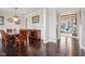 Dining room featuring hardwood floors, wooden table and chairs, and view into an adjacent living area at 14747 Harvest Glen S Blvd, Fishers, IN 46037