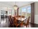 Spacious dining area features a large wooden table set, hardwood flooring, and large sunny windows at 14747 Harvest Glen S Blvd, Fishers, IN 46037