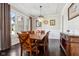 Dining room with modern chandelier, wood floors, large windows and a wooden table with seating for eight at 14747 Harvest Glen S Blvd, Fishers, IN 46037