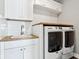 Laundry room featuring white cabinets, tile backsplash, and a countertop over the washer and dryer at 14747 Harvest Glen S Blvd, Fishers, IN 46037