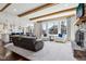 Spacious living room featuring stone fireplace, wood beam ceilings, and large windows at 14747 Harvest Glen S Blvd, Fishers, IN 46037
