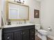 Stylish half-bathroom with a dark vanity and framed mirror at 14747 Harvest Glen S Blvd, Fishers, IN 46037