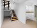 Basement features open stairs, carpeted floor, and a bathroom with white subway tile at 1537 Carrollton Ave, Indianapolis, IN 46202
